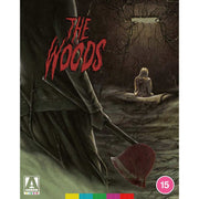 The Woods Limited Edition Blu-Ray cover showing a person holding an axe in a dark forest with a girl sitting on a tree branch, atmospheric horror artwork
