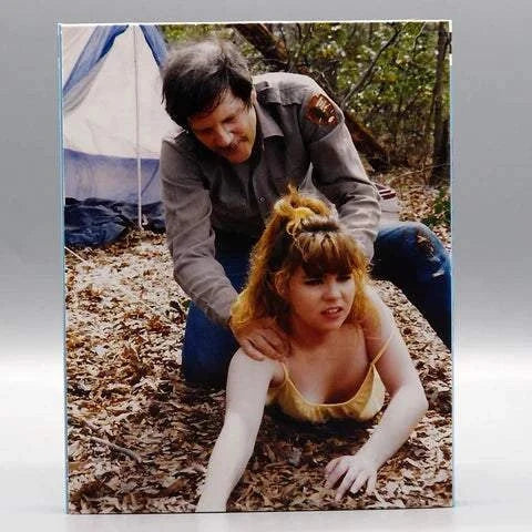 Saturn's Core Bloody Creek Blu-Ray cover showing a camp ranger and distressed young woman in forest camping scene