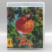 Boys Go to Jupiter Blu-Ray with limited edition slipcover featuring animated boy sitting on large orange fruit against green foliage background.