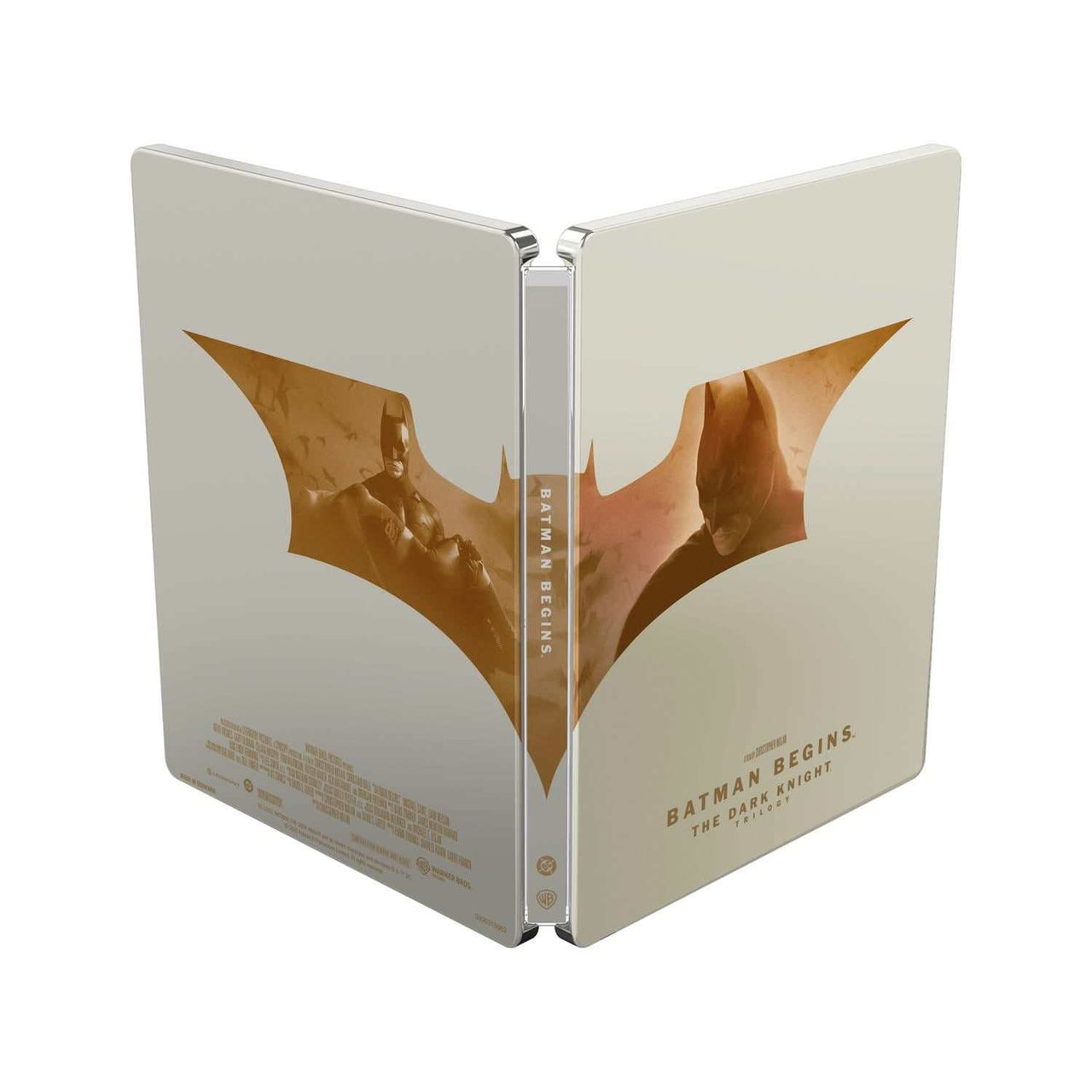 The Dark Knight Trilogy limited edition steelbook with Batman Begins artwork in gold and beige tones, 4K Ultra HD and Blu-Ray, region free, UK pre-order.