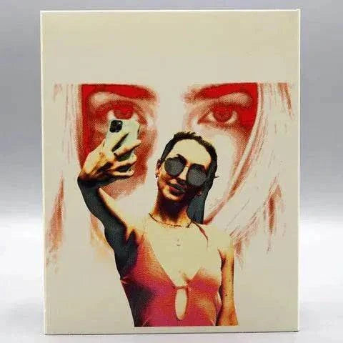 Shudder Influencer Blu-Ray slipcover featuring woman taking selfie with large eyes in red behind her.